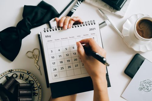 Frau trägt Termin in Kalender ein