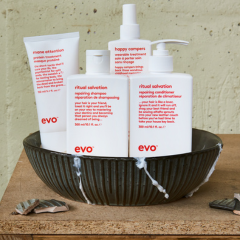 Mehrere Haarpflegeprodukte von evo Repair stehen in einer Schüssel auf einer Holzoberfläche