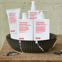 Mehrere Haarpflegeprodukte von evo Repair stehen in einer Schüssel auf einer Holzoberfläche